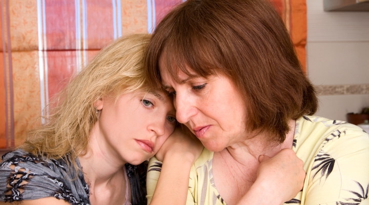 Grieving mother and daughter holding each other for comfort.