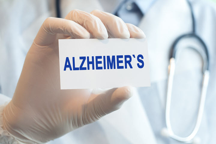 doctor holding card in hand that says alzheimers