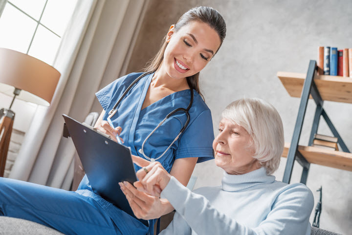 smiling female nurse showing Alzheimer's test to woman