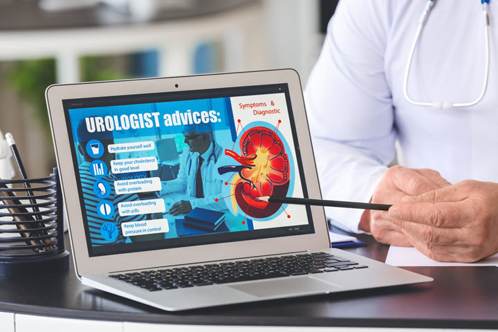 urologist pointing to a laptop explaining UTI symptoms and diagnosis